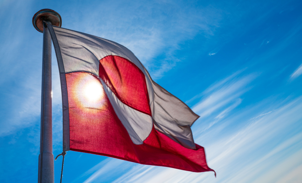 Billede af Grønlands flag mod blå himmel.
